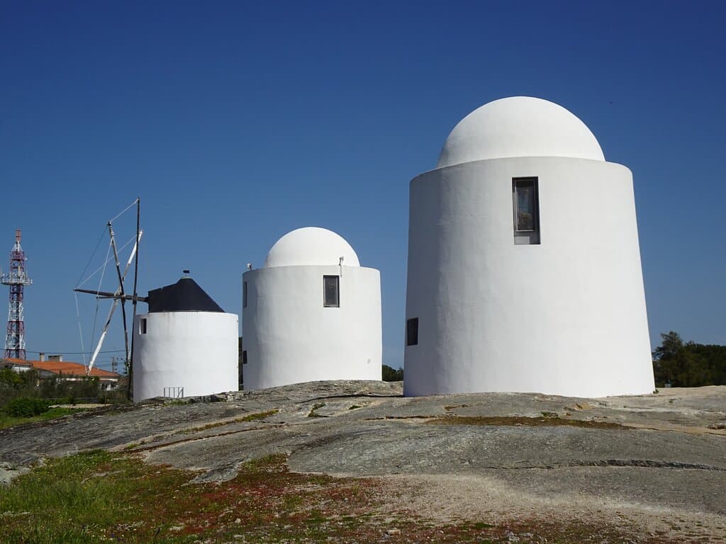 Odnowione wiatraki na szczycie granitowego wzgórza.