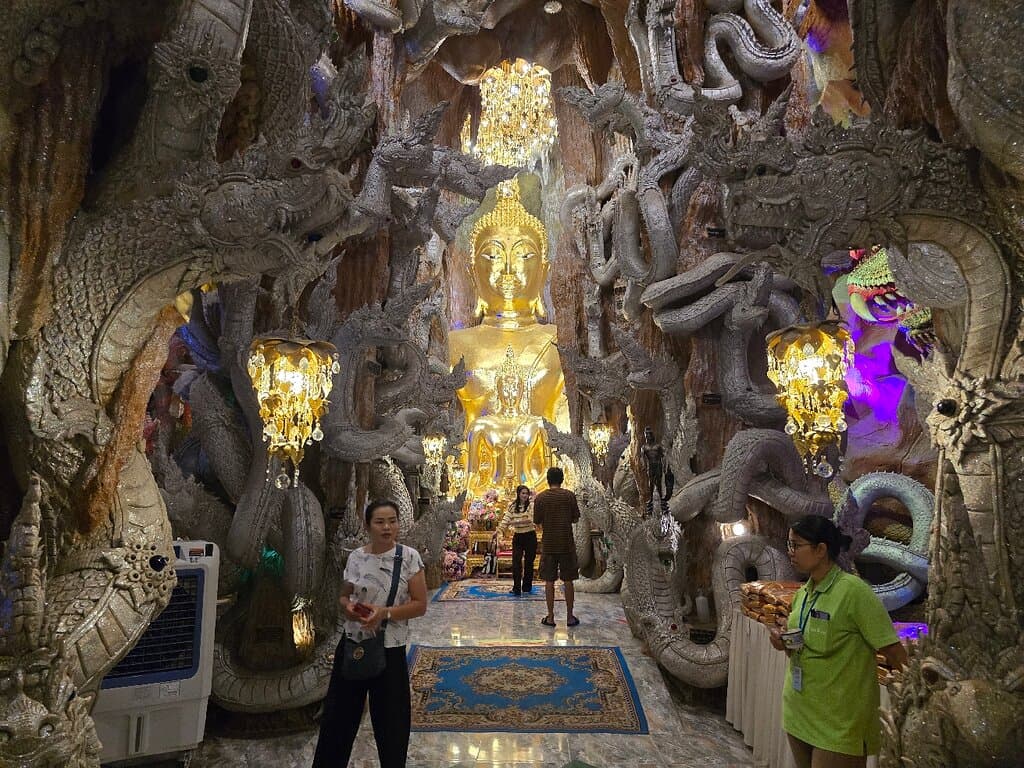 ด้านหน้าทางเข้าอาคารที่เป็นที่ตั้งของถ้ำจะพบกับสะพานที่เป็นประติมากรรมปูนปั้นที่จำลองการข้ามห้วงนรก ตัวสะพานจะเป็นพญานาคห้าเศียรพร้อมองค์พญานาคจำแลงที่อยู่ในสระบัว ซึ่งด้านข้างถัดจากสระบัวจะเป็นห้วงนรกที่มีมือจำนวนมากชูขึ้นมา ถือว่าเป็นงานศิลป์ชั้นยอดที่ประณีต และแฝงคติธรรมข้อคิดได้เป็นอย่างดีครับ